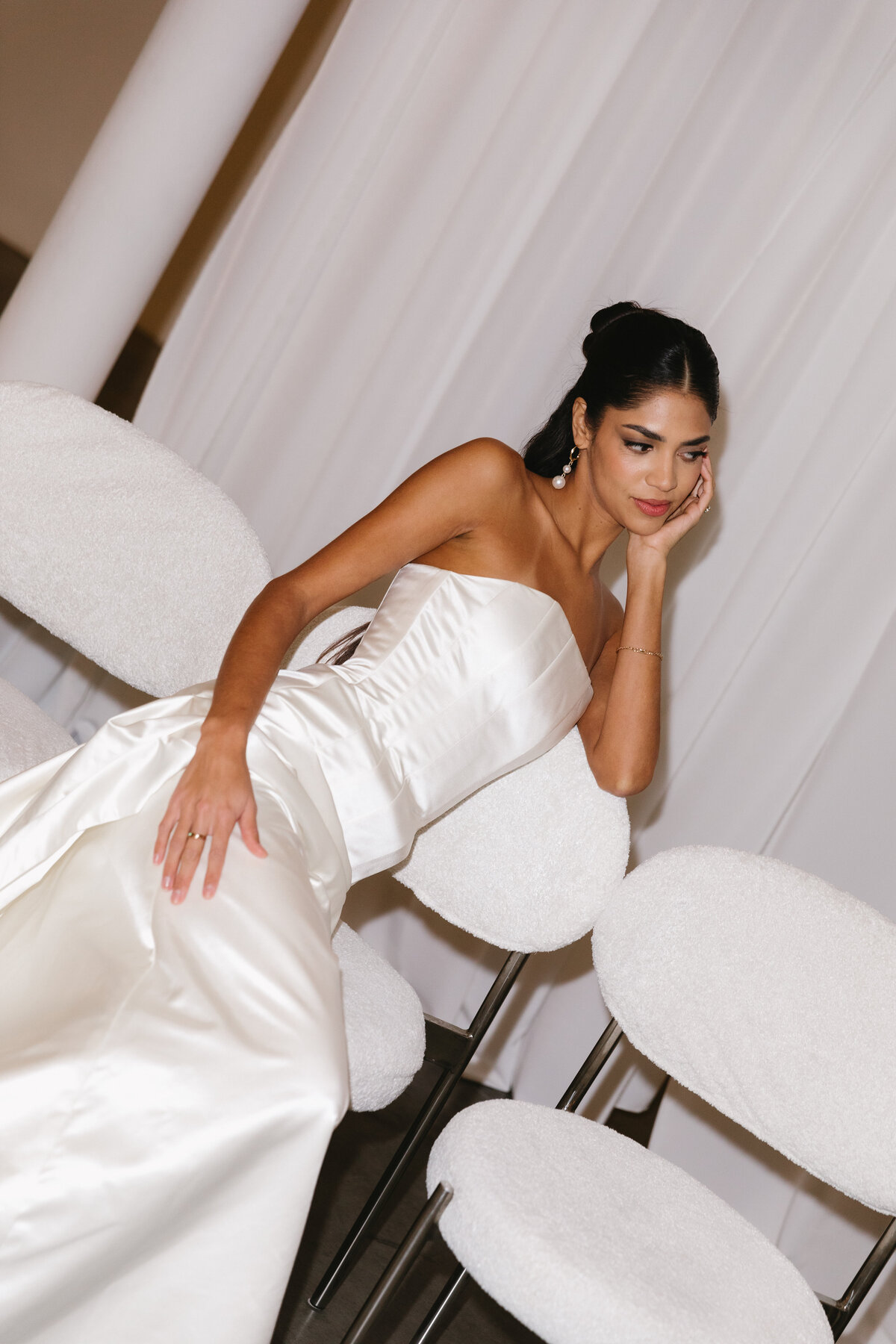 Close-up of an editorial bridal gown with structured satin detailing and refined styling.