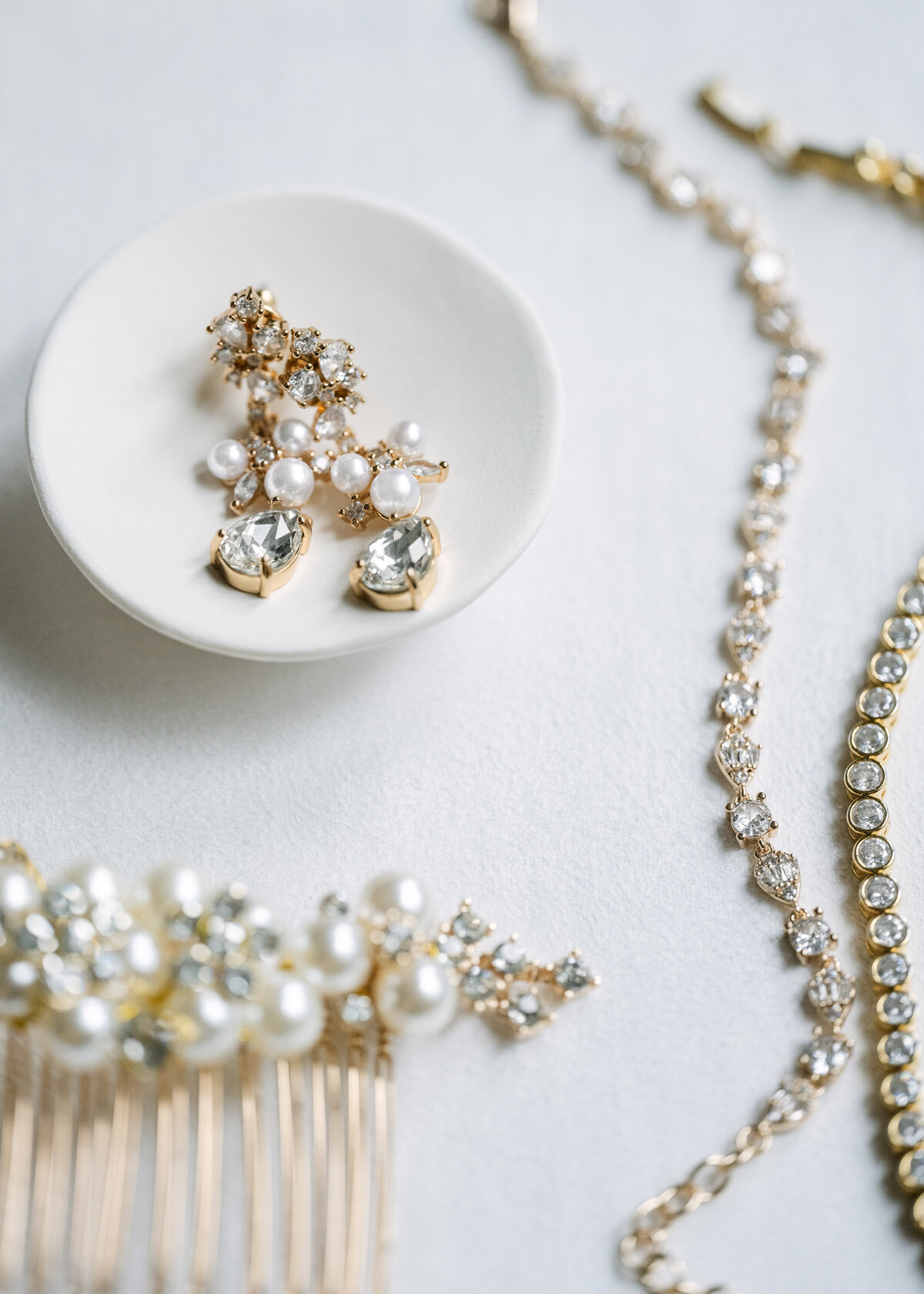 wedding day earrings, hair clip, and bracelets with pearls and diamonds