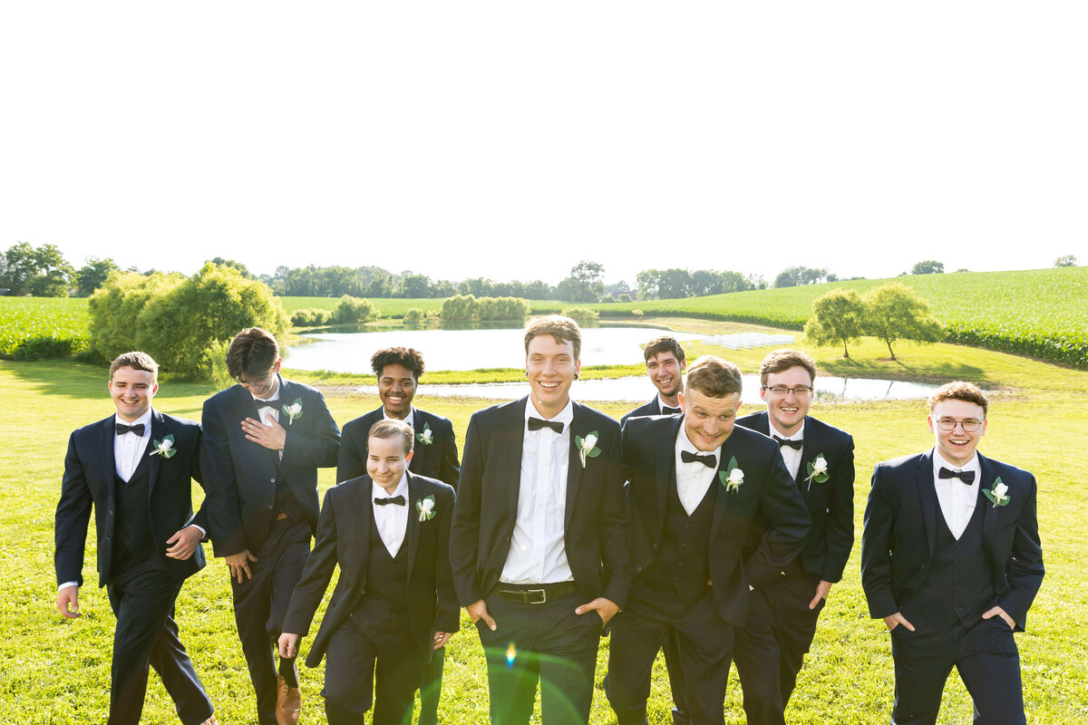 Groom with groomsmen in black suits at the Ruby Cora wedding venue in Clarksville, TB