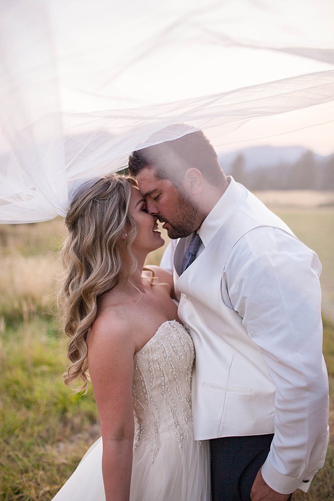 bride and groom kissing under veil in Applegate Oregon