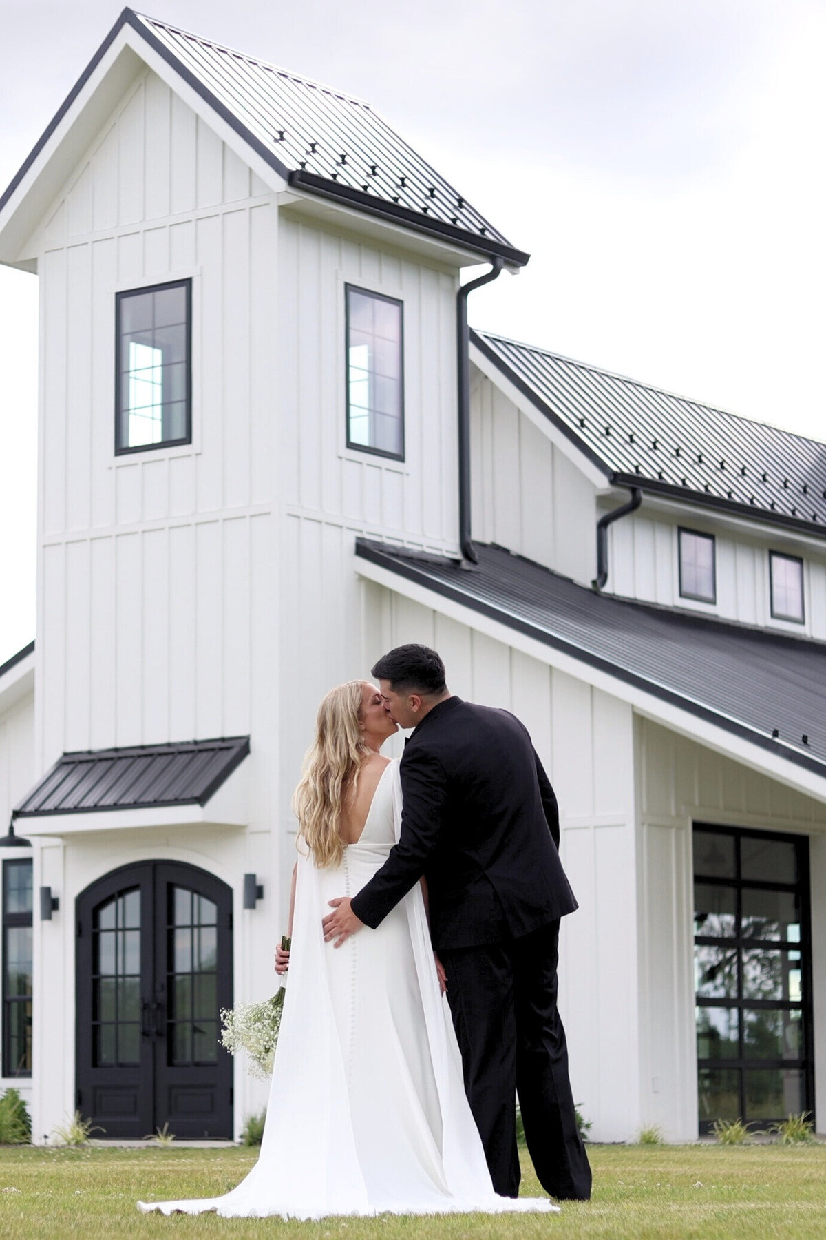 Bride and Groom kissing in front of chapel at The Brim