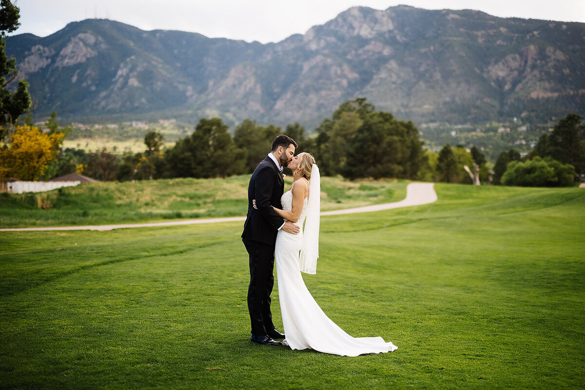 Bride and groom share a kiss in front of the Colorado Mountains.