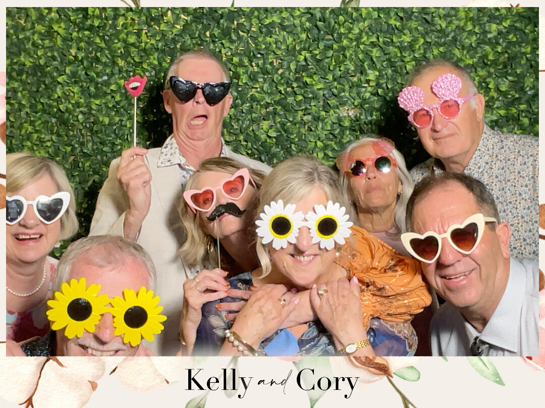 a group of wedding guests with fun sunglasses props in a photo booth at a christchurch wedding