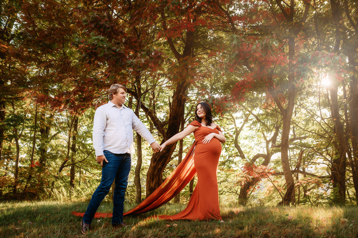 Expectant parents pose for autumn Maternity Photos on the Blue Ridge Parkway in Asheville, NC.