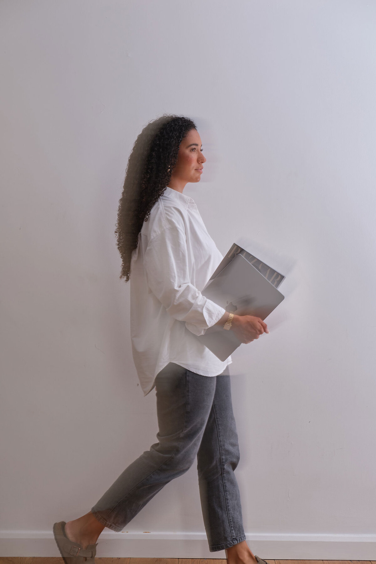 Woman walking with laptop in hand