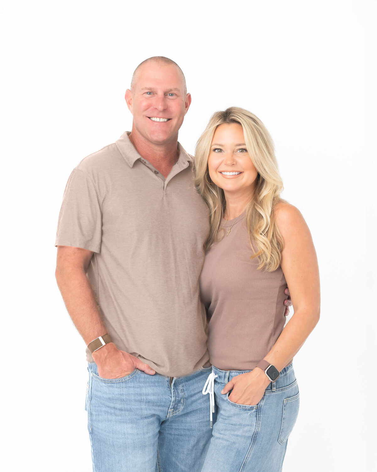 Cutest husband and wife studio portrait on white with beige shirts and blue jeans
