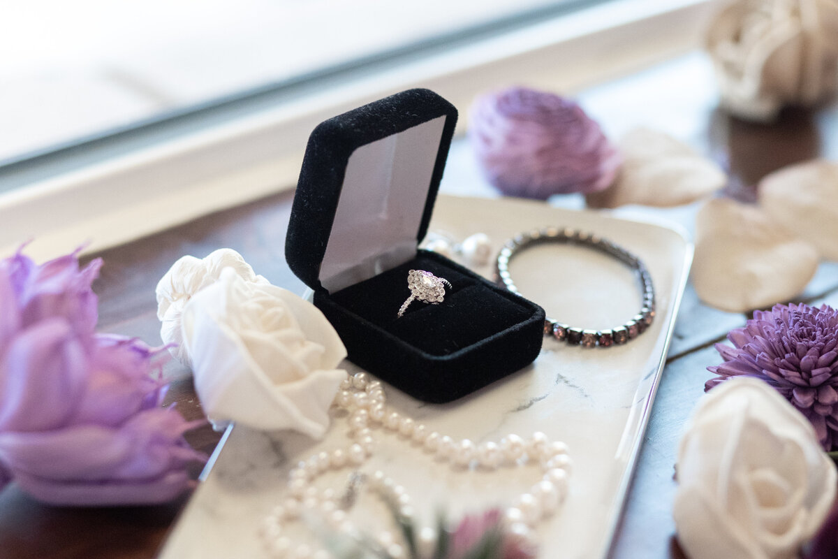 Flat lay detail photo with flowers engagement wedding ring and jewelry
