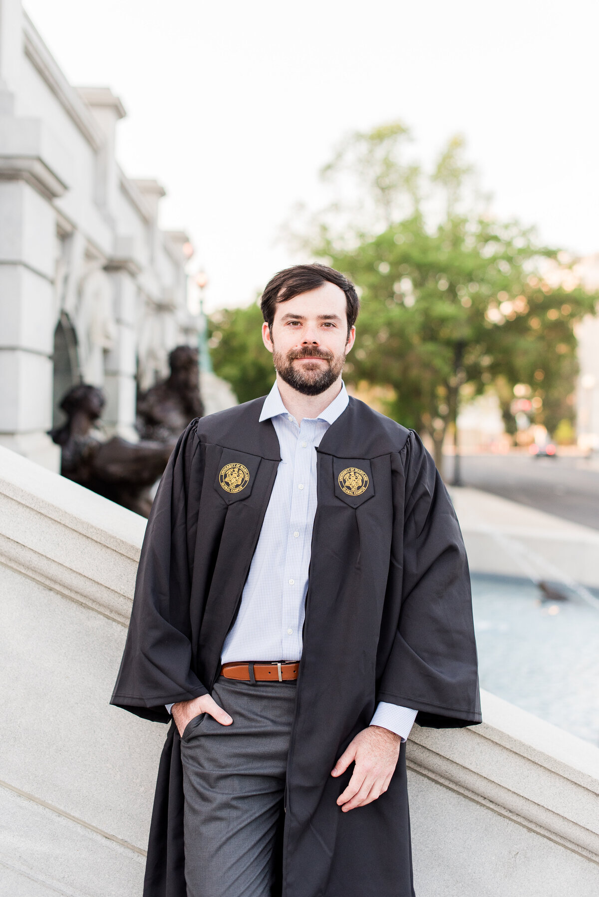 law grad standing on marble steps