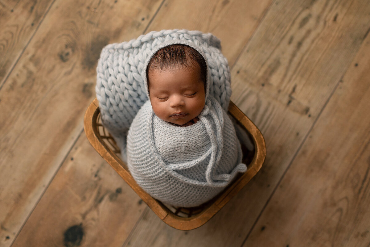 baby boy wrapped in light blue for his newborn photos in loveland