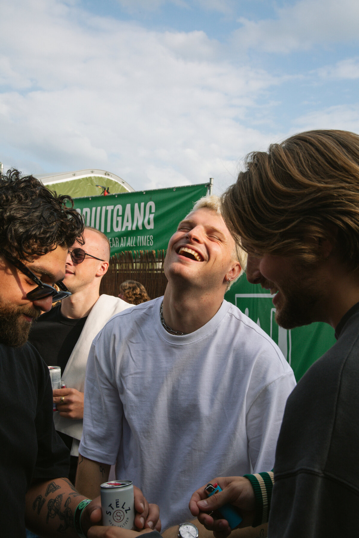 Sam Hofman bursts into laughter with friends backstage at a festival, captured by Bo Eppink.