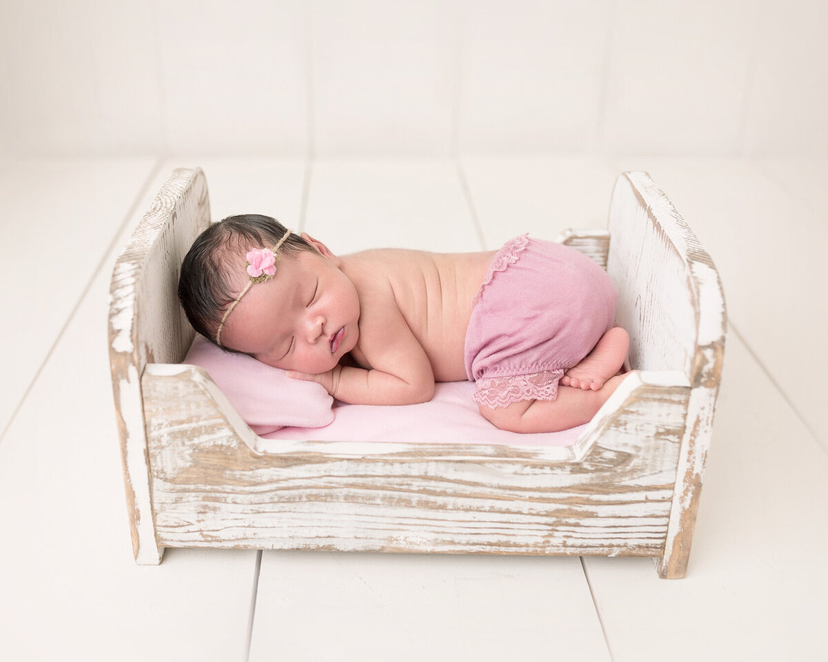 Creative newborn photoshoot in a tiny bed by Laura King photography
