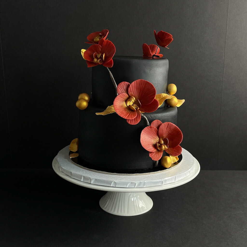 Bold black coloured two-tiered textured wedding cake, with cascading sugar flowers, created by Chartier YYC, elegant cakes & desserts in Calgary, AB, featured on the Brontë Bride Vendor Guide.
