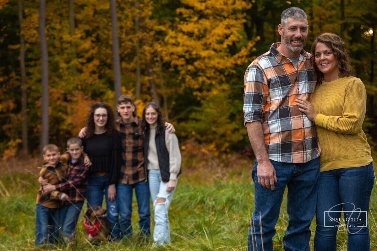 Parents hug with kids in background