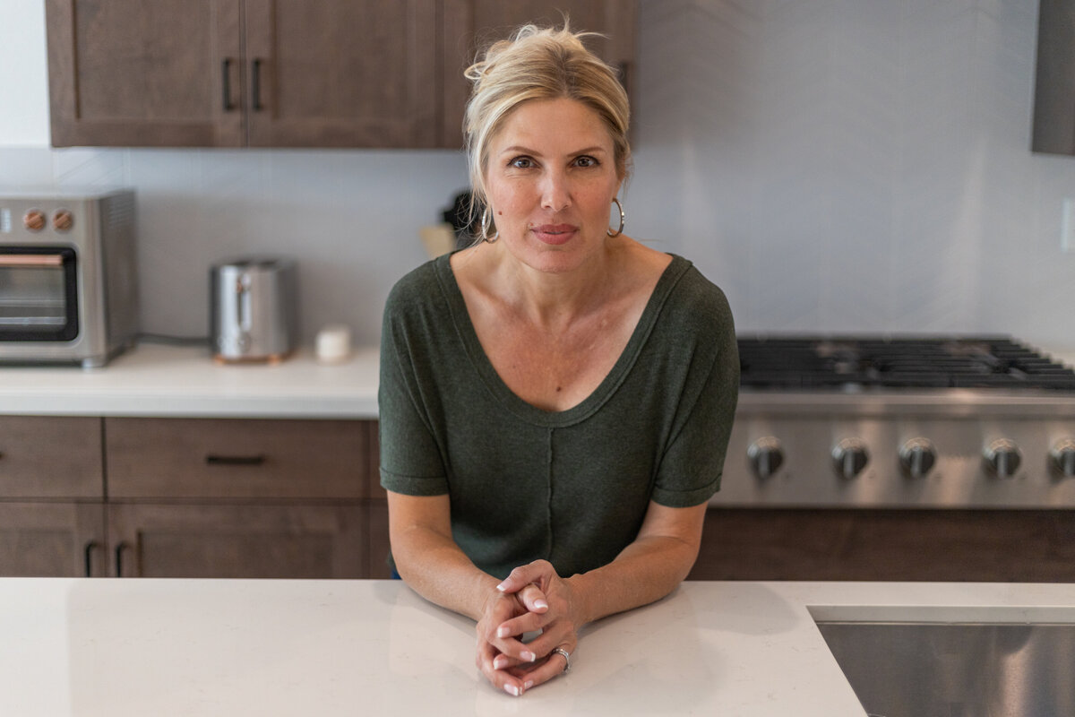 Laura Bogart at home leaning on kitchen countertop