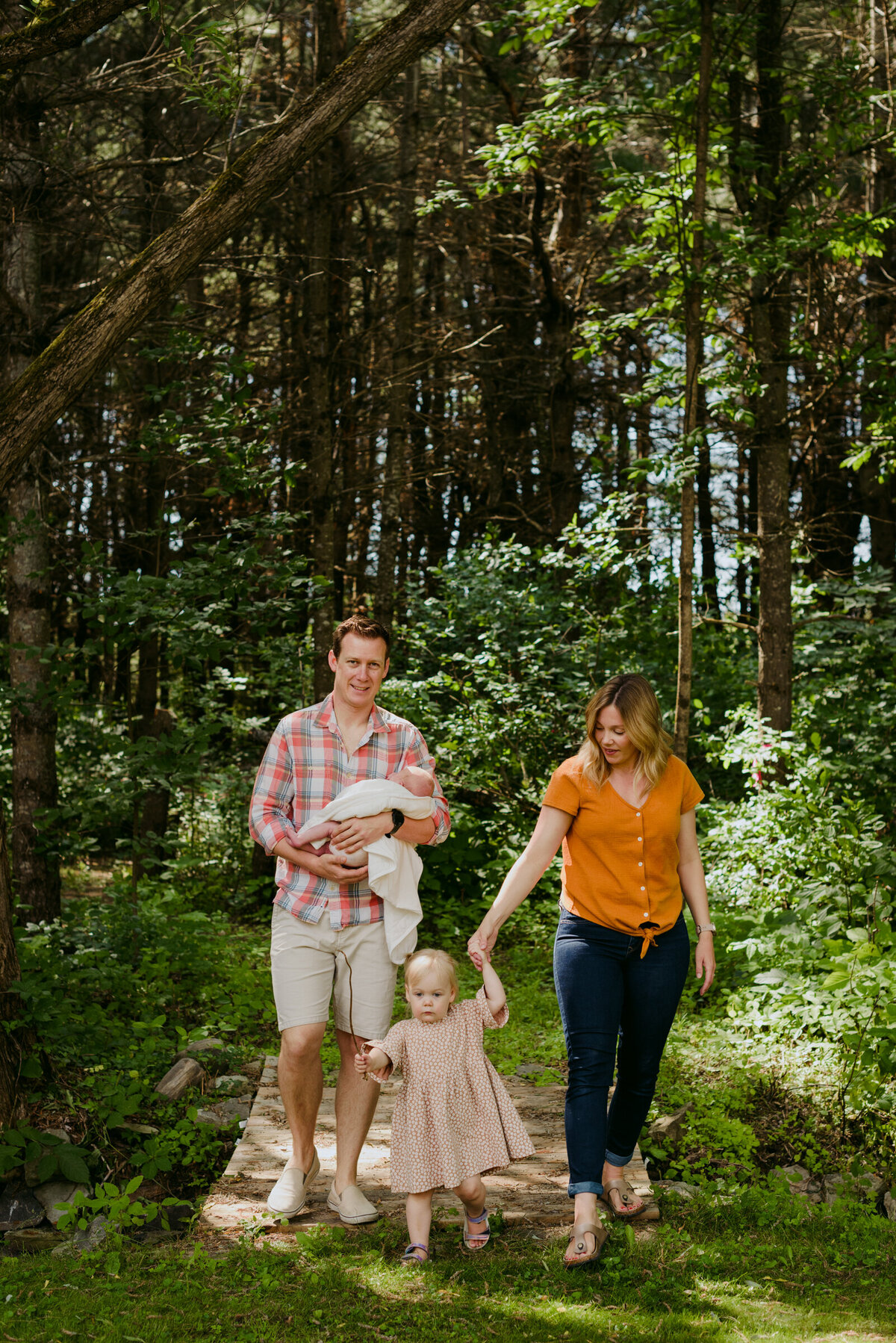 Family of 4 walking outdoors in the forest