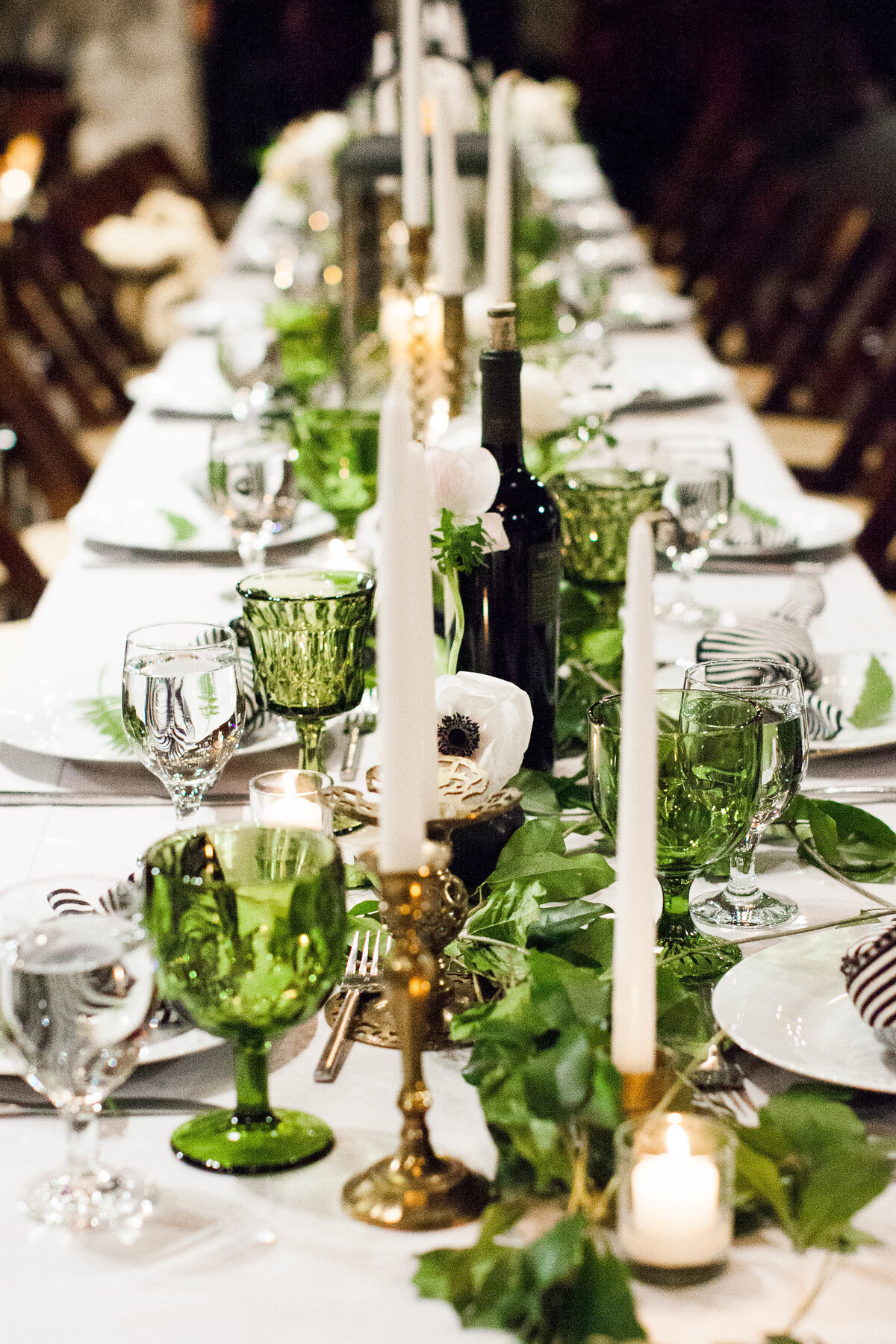 Long head table with greenery and vintage water glasses