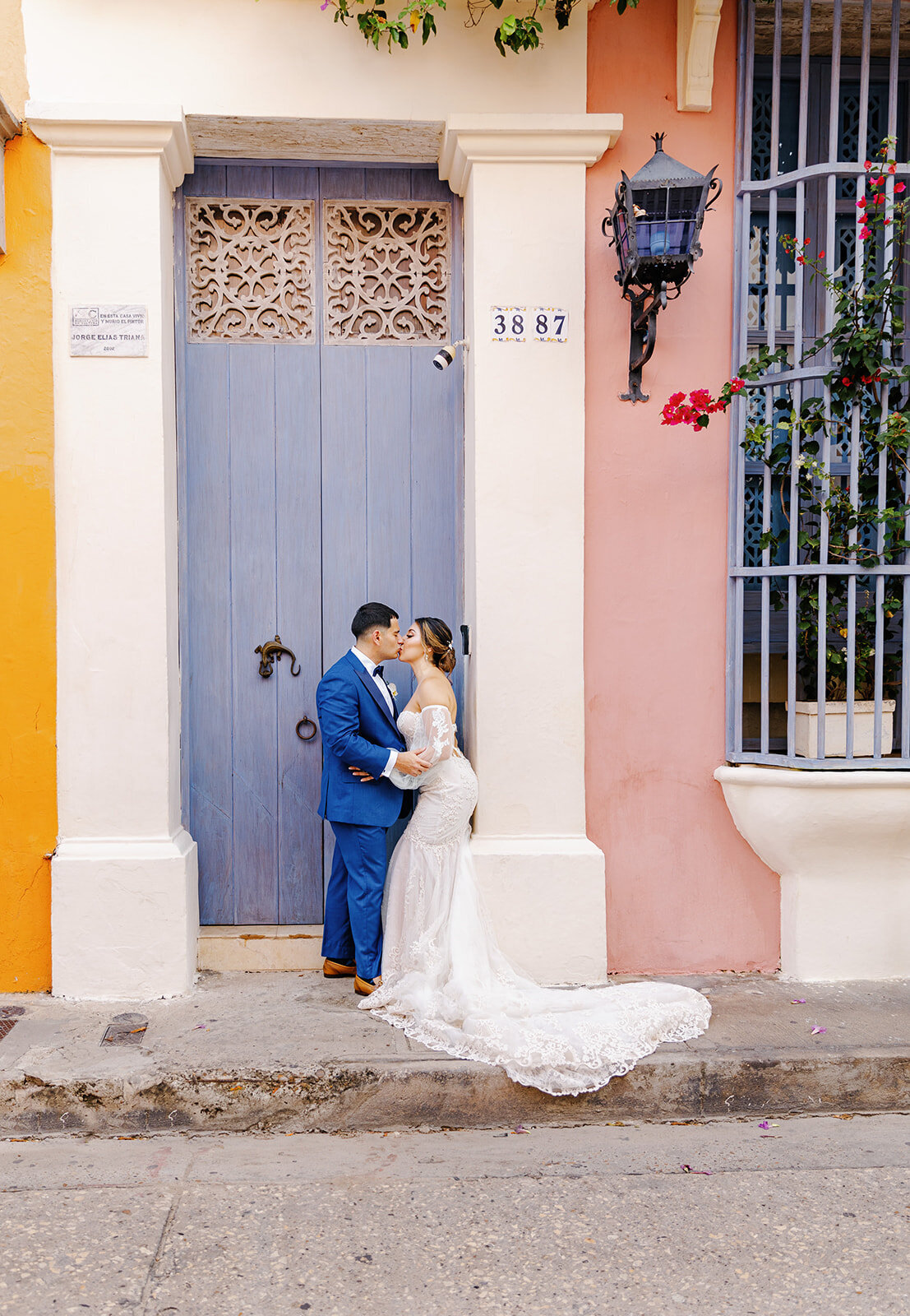 Victoria and Daniel pose with a pop of Cartagena’s colorful architecture, standing in front of a historic blue door.