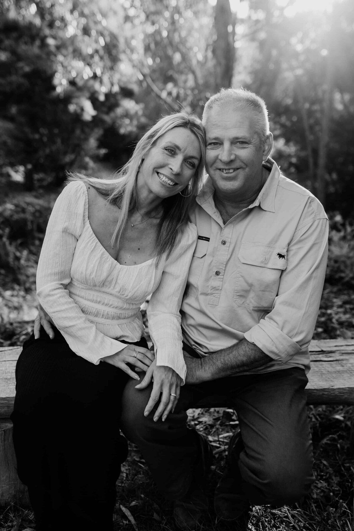 Black and white photo of older couple sitting on bench during mature aged couple photoshoot Melbourne