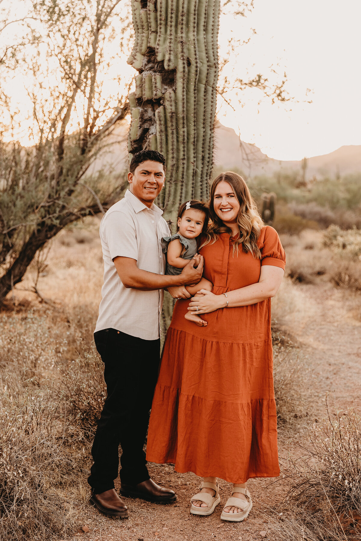 family of 3 posing for family session at sunset in phoenix