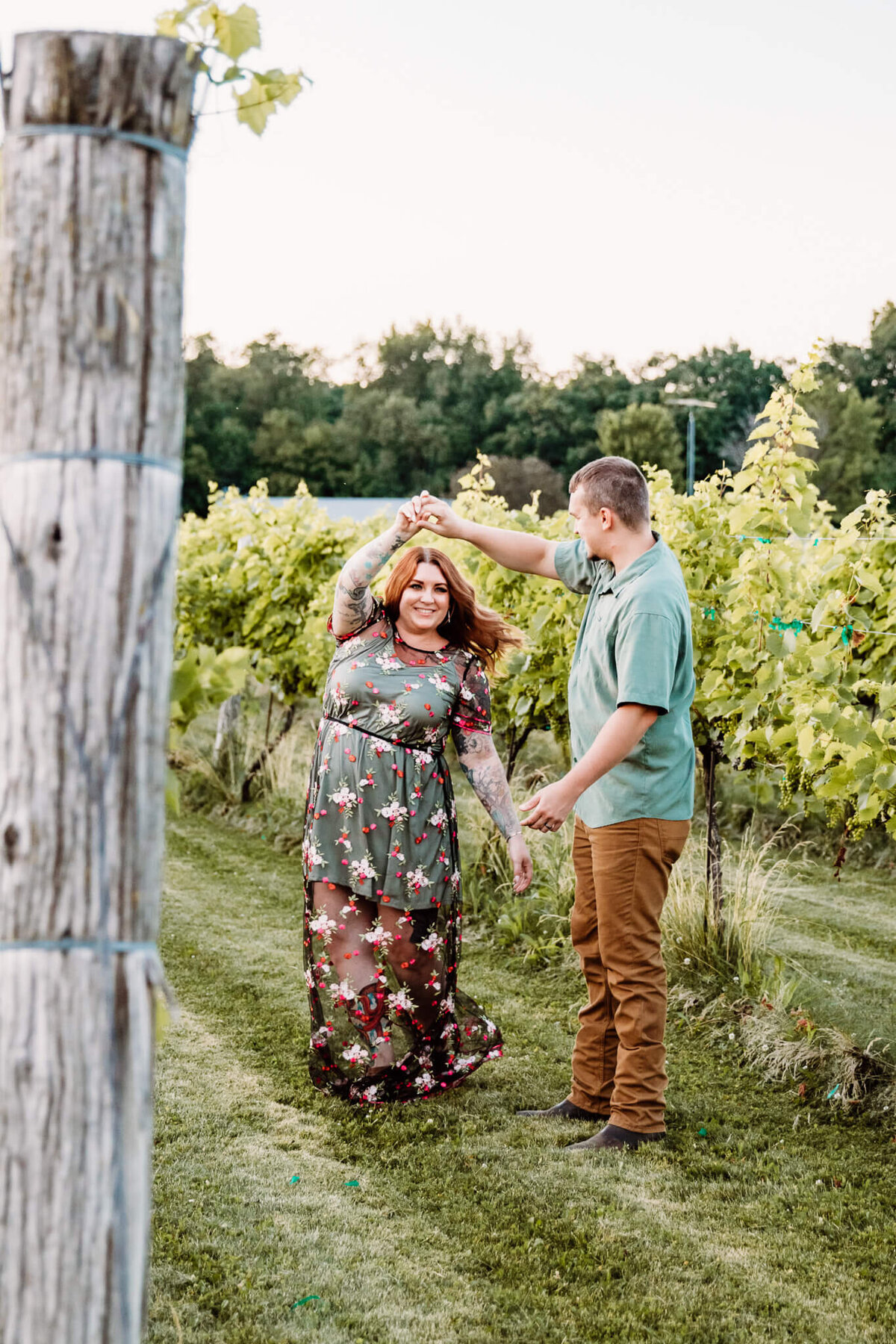 husband twirling wife in a vineyard
