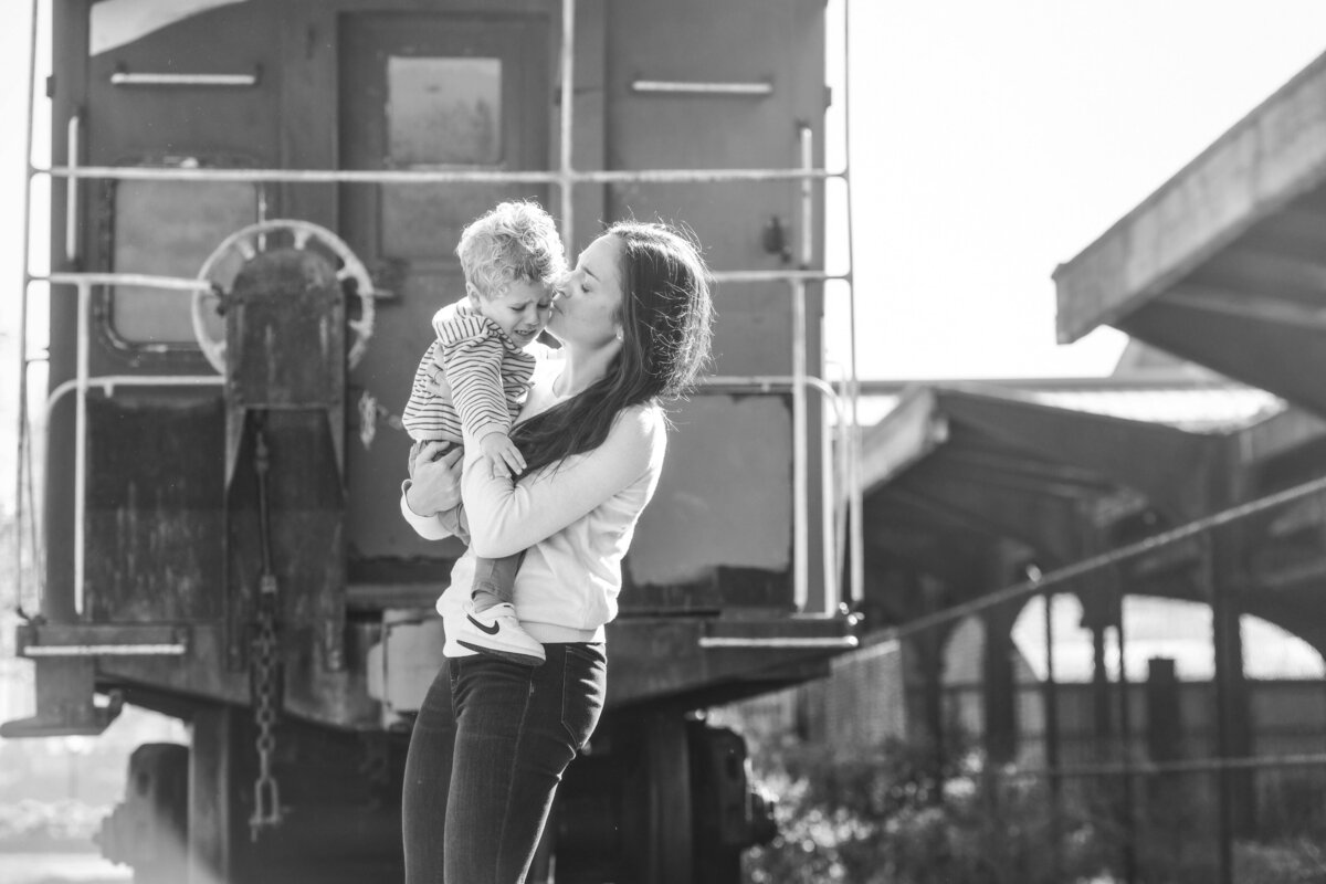 A mom holding her child and kissing their head