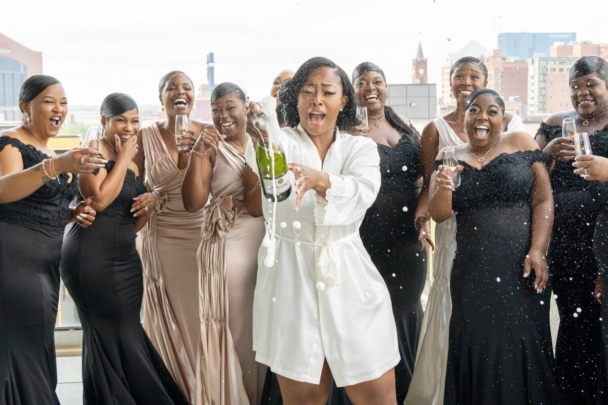 bride-popping-champagne-with-bridesmaids-alexander-hotel.jpg