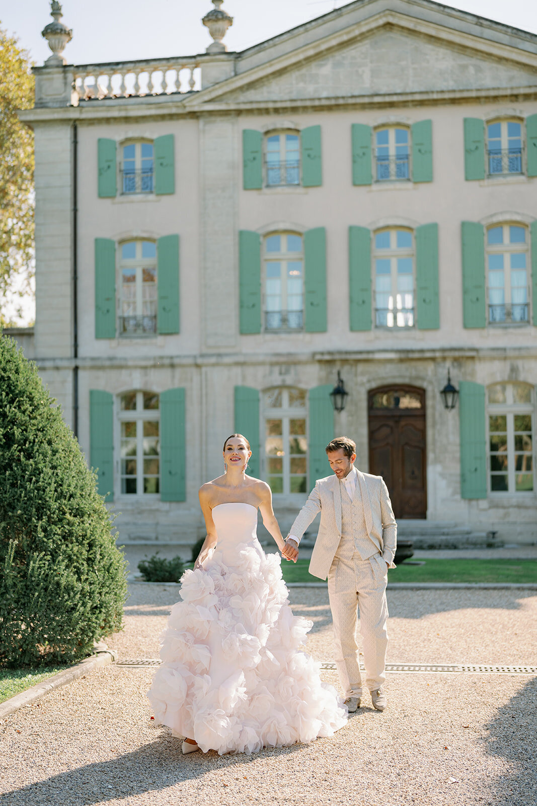 Full symmetrical front view of Château de Tourreau with French windows, hedges, and afternoon light.
