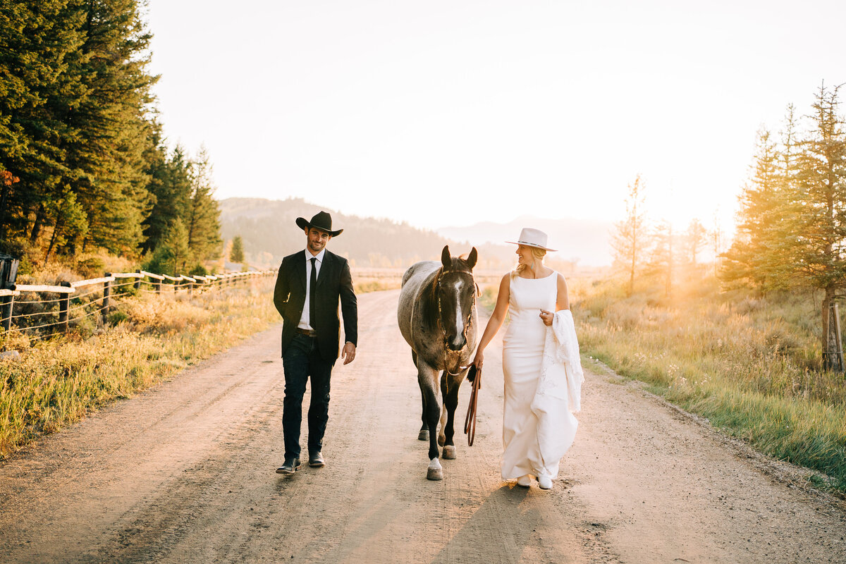 Couple walking with their horse at golden hour
