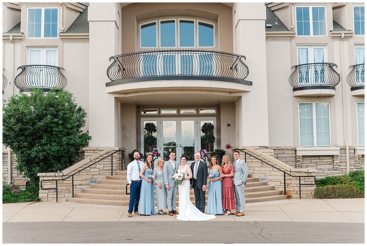 A family stands in front of the chateaux at fox meadows for family portraits on a wedding day captured by denver wedding photographer