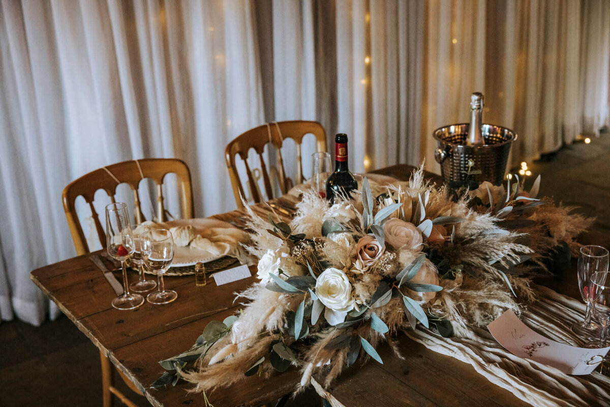 A wooden table topped with a vase filled with flowers