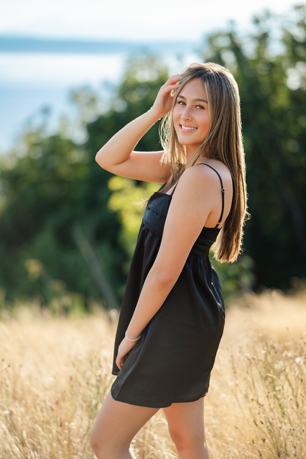 kirkland senior standing on discovery park bluff in black dress