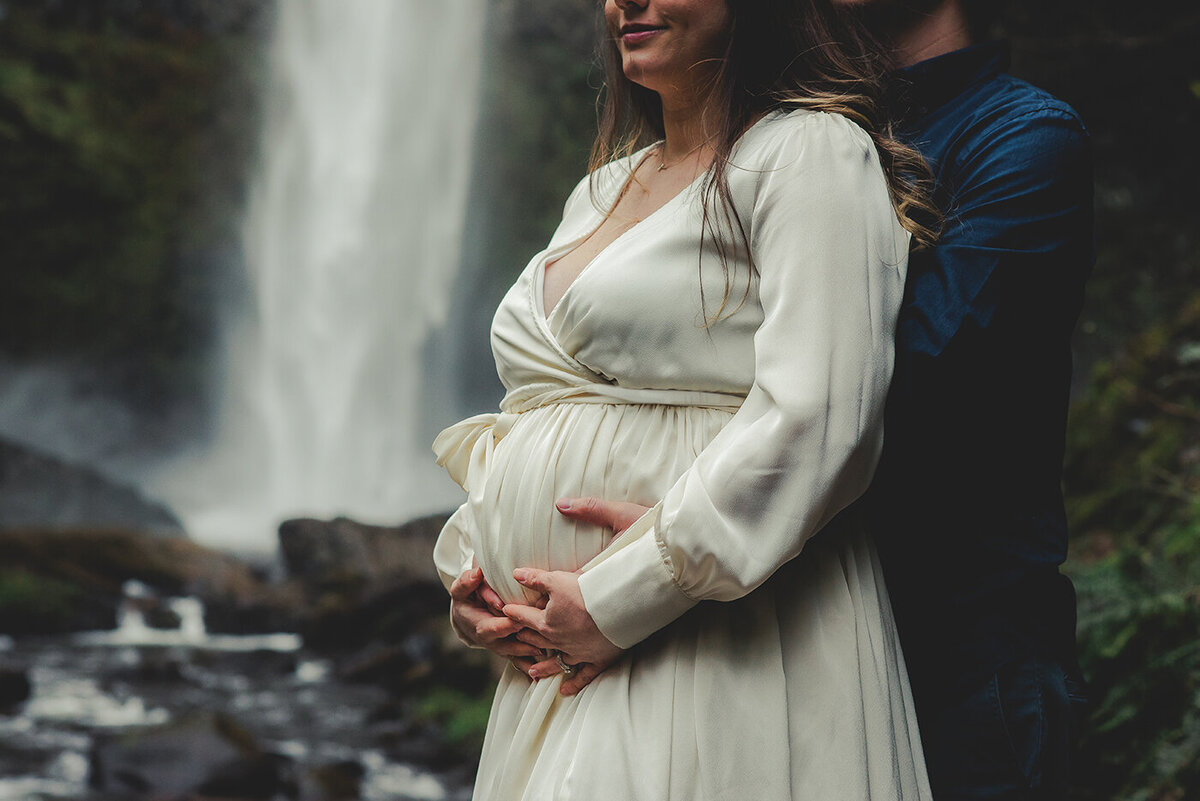 pregnant couple and waterfall