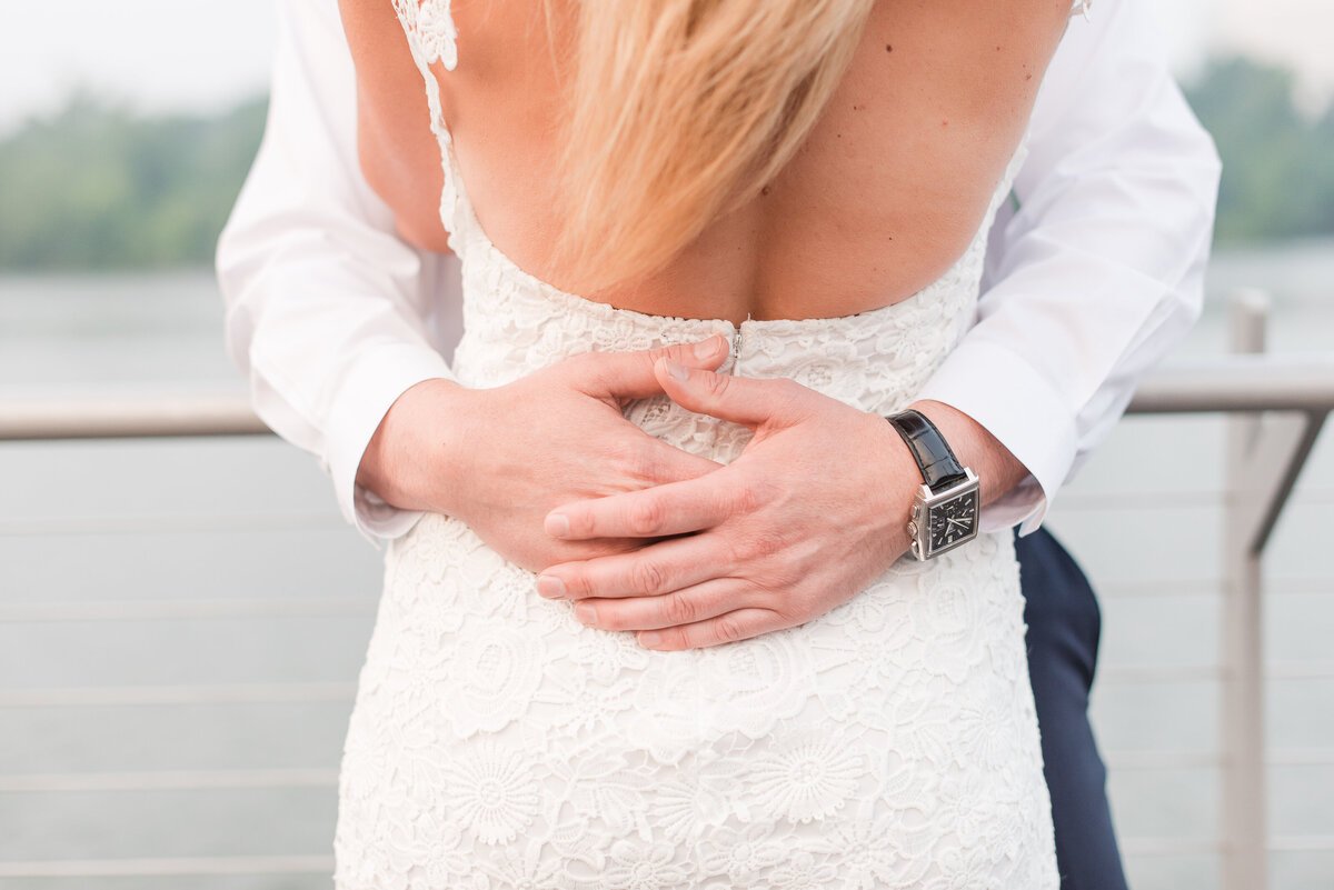 close up of groom hands on girls waist