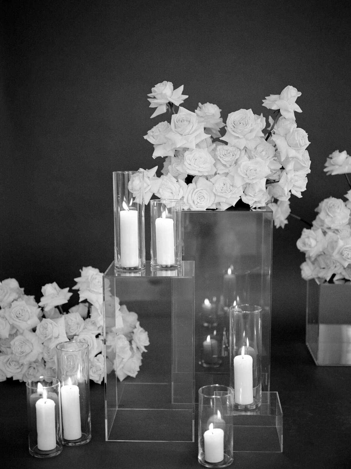 abundant white roses, candles, clear pillars, dark background for florist branding photos 