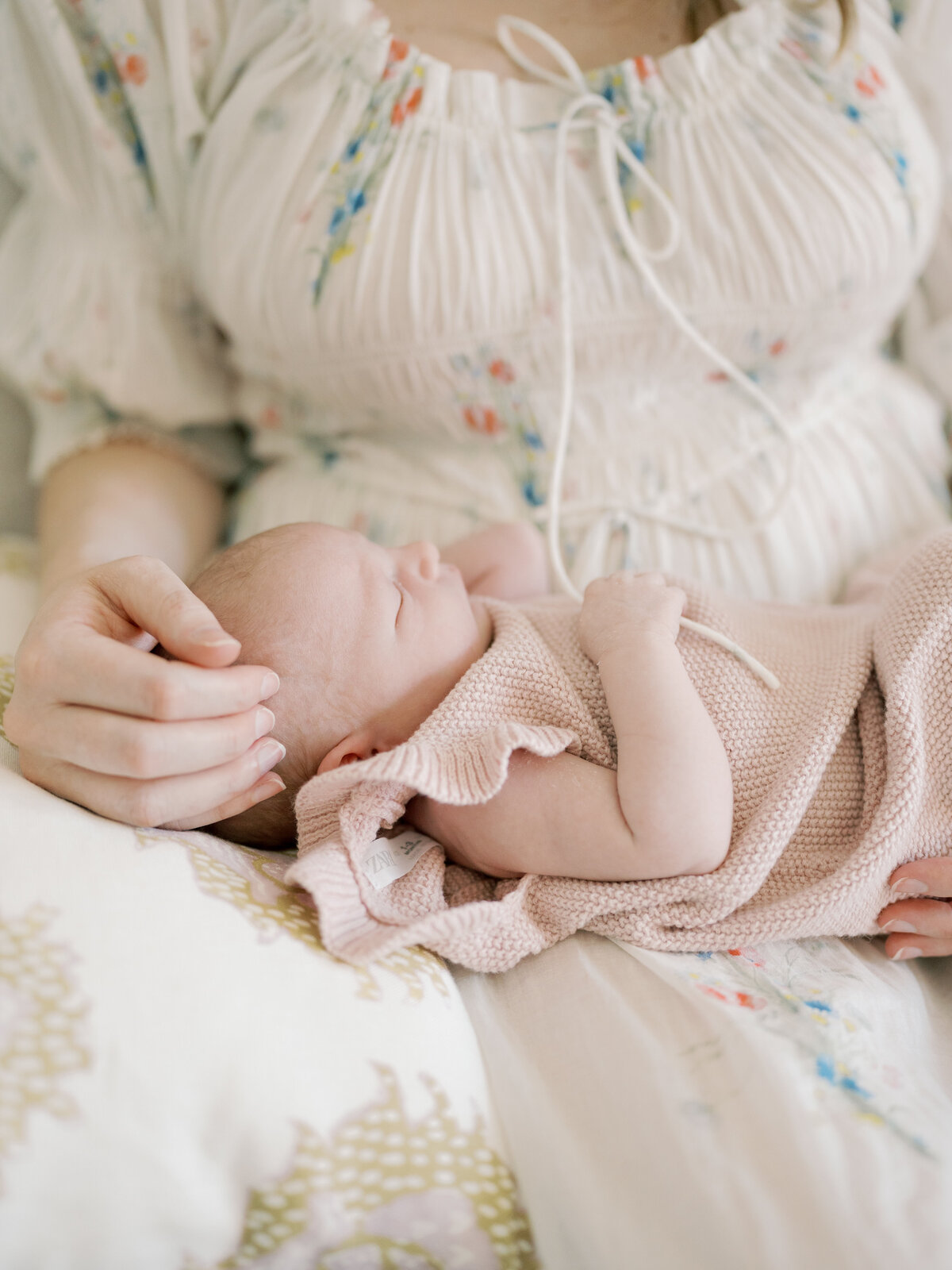 Mom holding sleeping newborn baby and rubbing her head in Williamsburg Virginia
