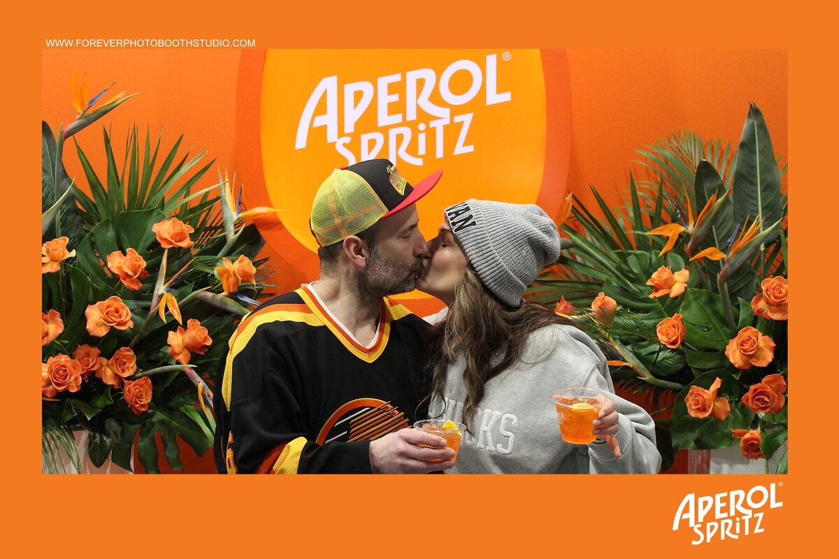 Couple taking a picture together at an aperol spritz event