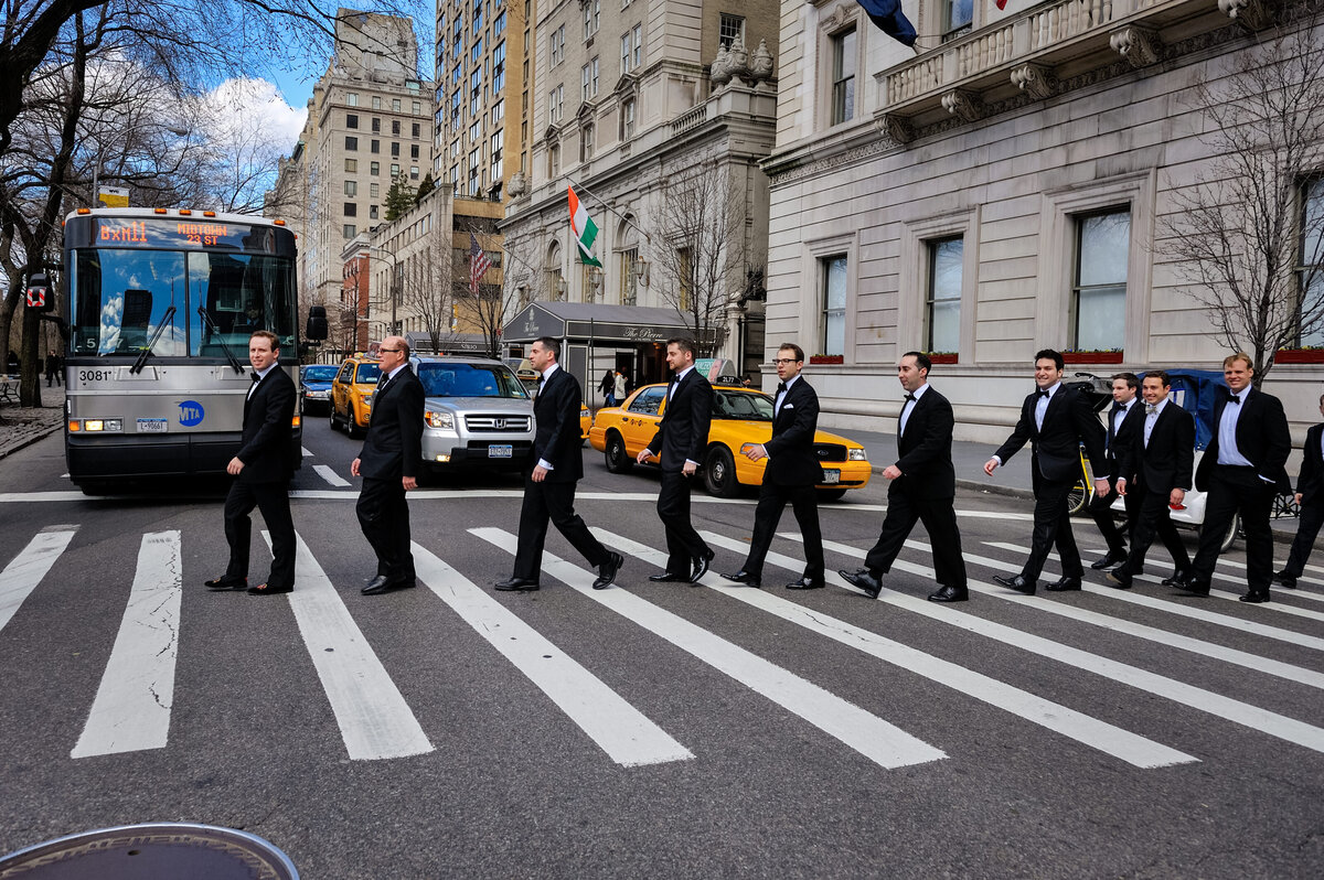 Groomsmen in tuxedos crossing a busy street in New York City, styled after the iconic Abbey Road image, by Rodrigo Varela Photography.