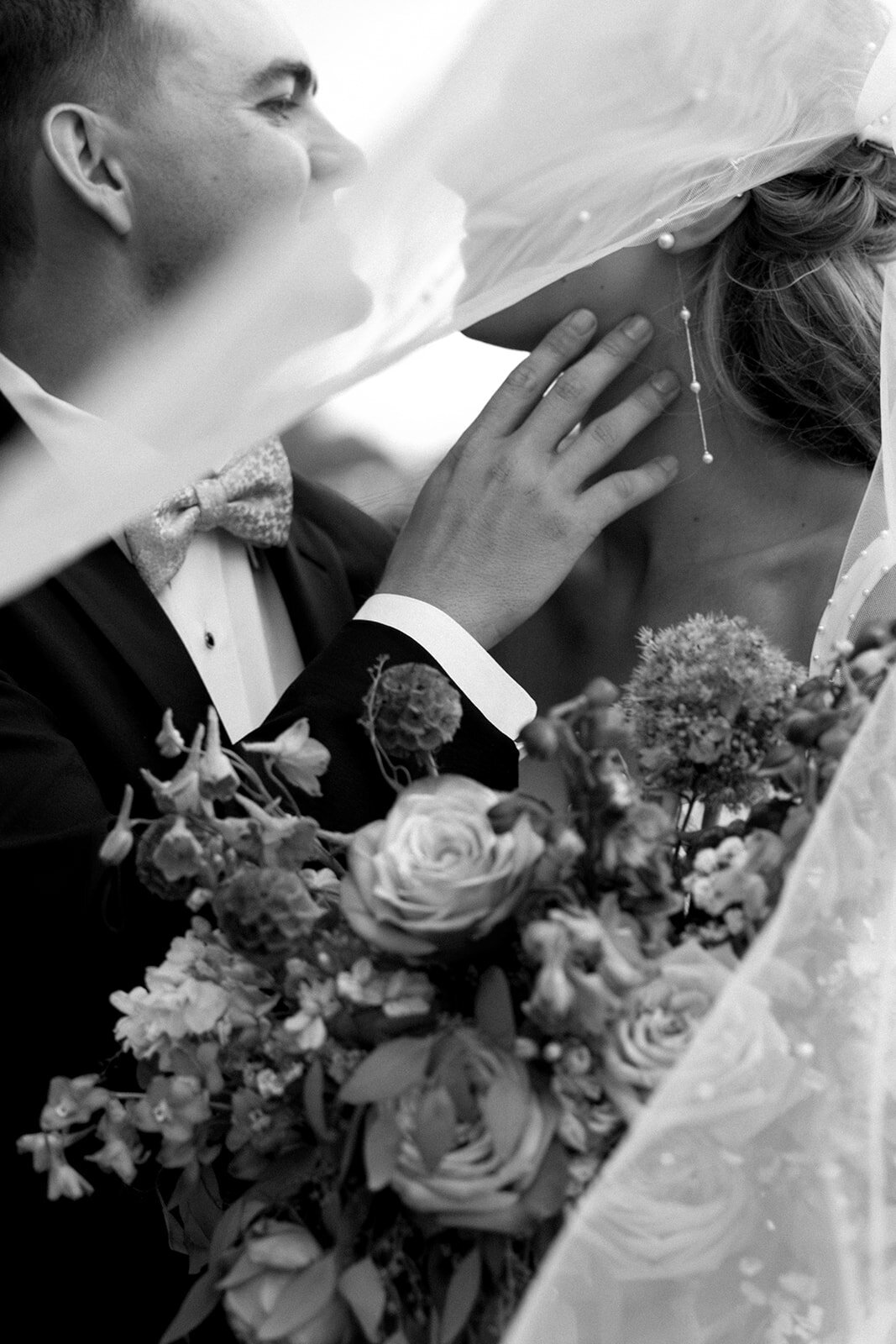 Big Sky wedding photographer portfolio: intimate black and white portrait of a couple embracing outdoors, highlighting the emotional connection in a mountain setting.
