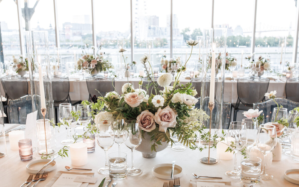 Tables decorated with centrepieces of lush, pastel garden flowers and greenery at a Science Centre wedding.