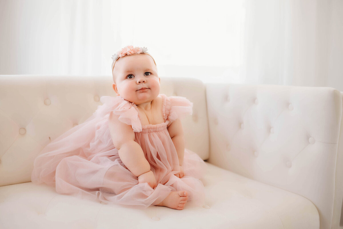 Baby looks into the camera during her first birthday, Milestone Photoshoot in Asheville, NC.