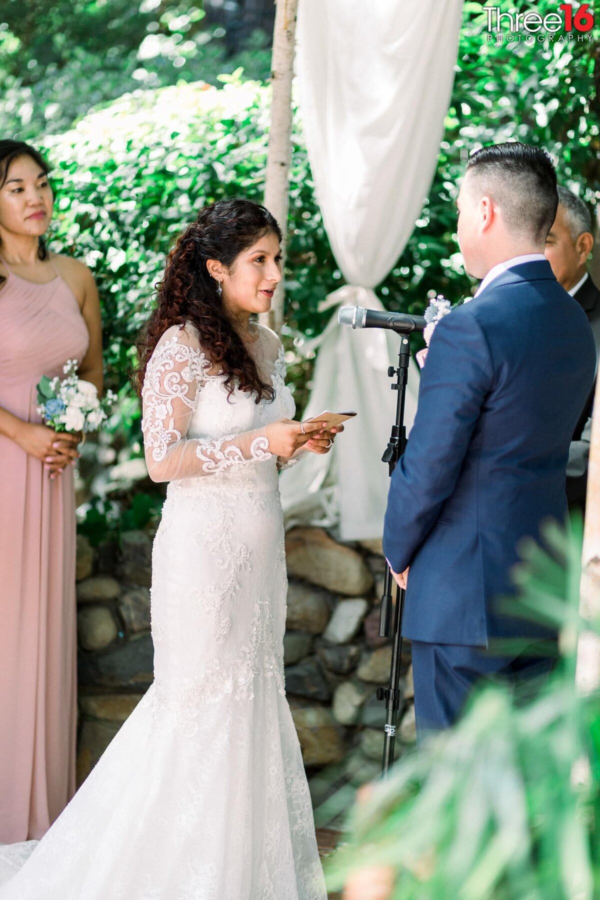 Bride reads her vows to her Groom into a microphone while standing at the altar