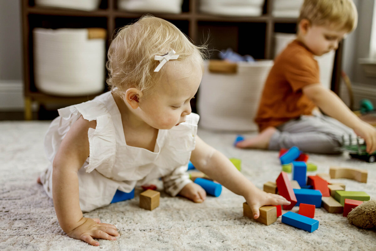 a toddler plays with blocks at in home photo session