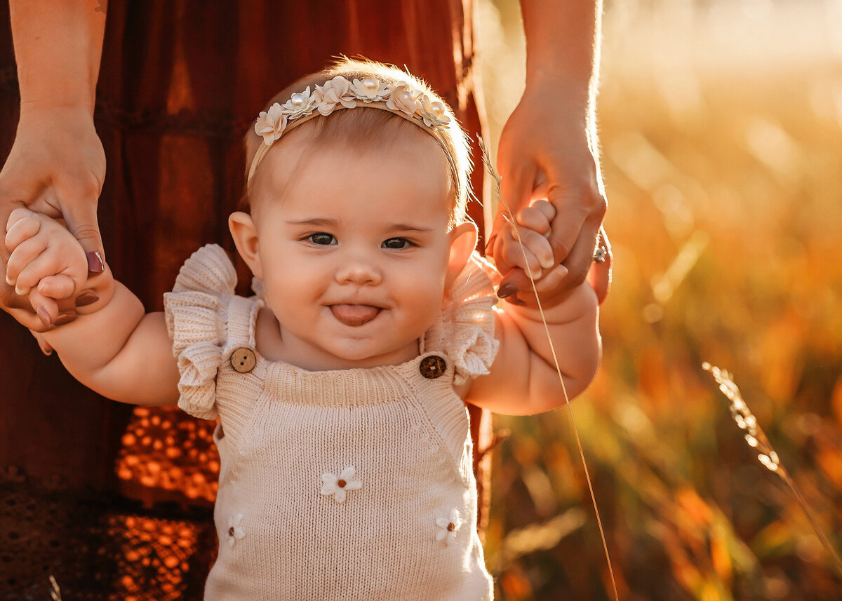 Mom holding daughters hands while she stands at their colorado family photography session.