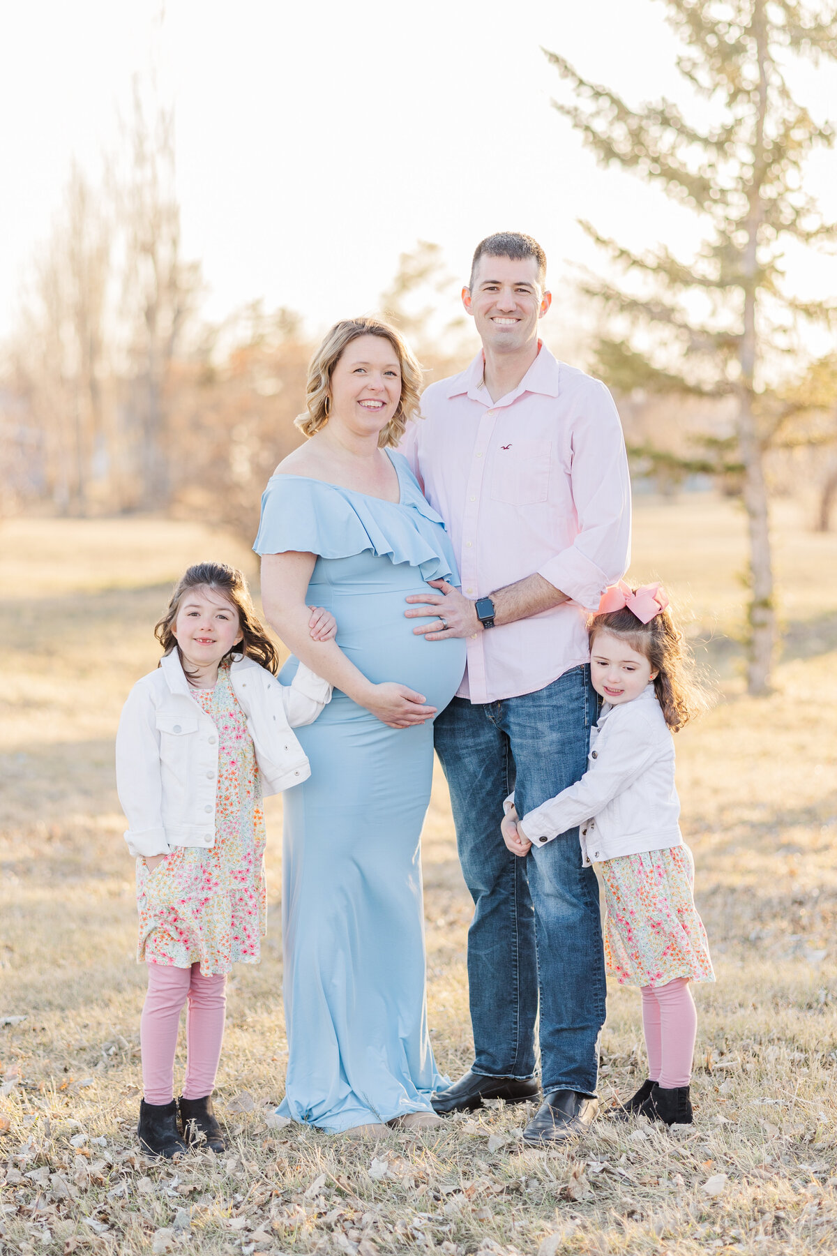 Family standing clost to pregnant mom