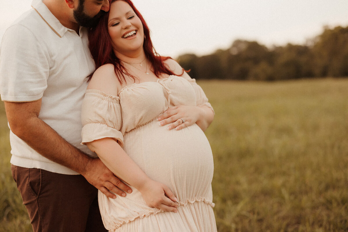 Pregnant woman walking in meadow during golden hour maternity session in Franklin Tennessee