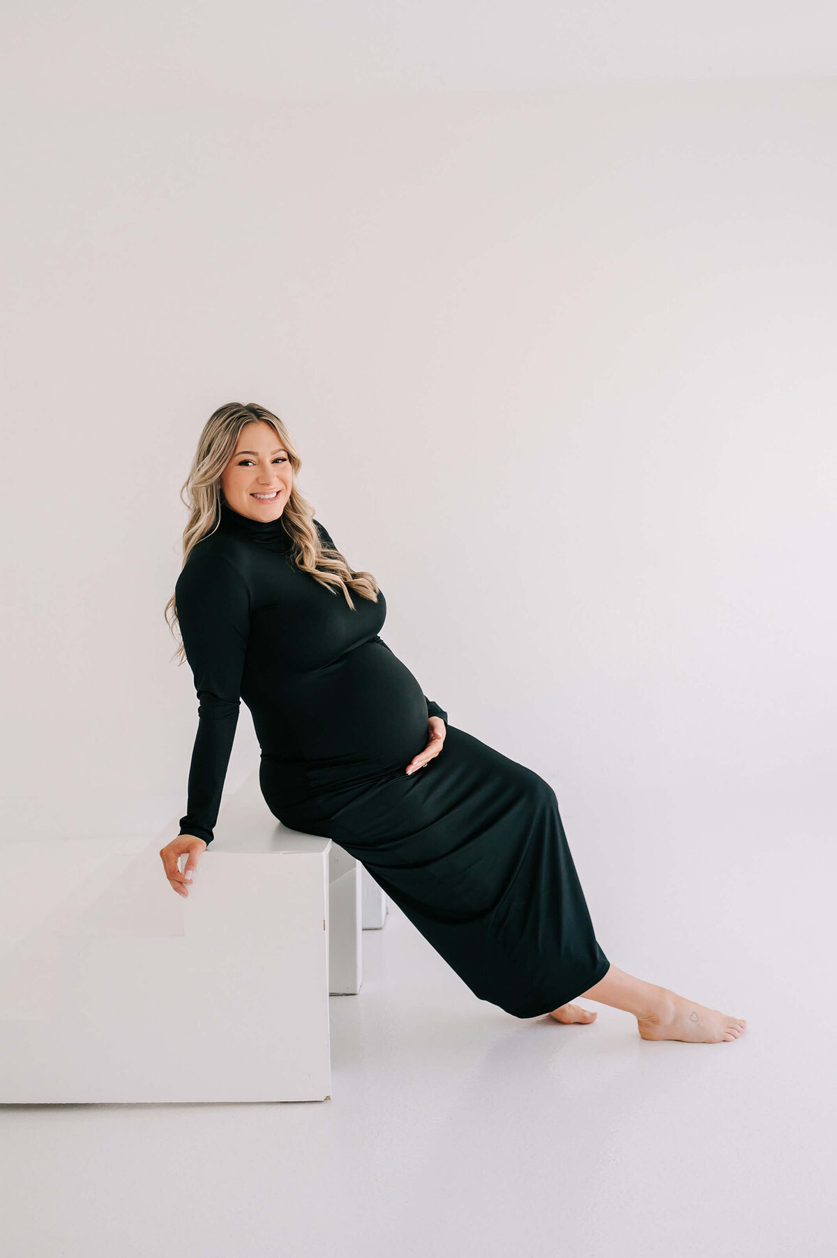 maternity picture in Branson MO of pregnant mom sitting on step smiling