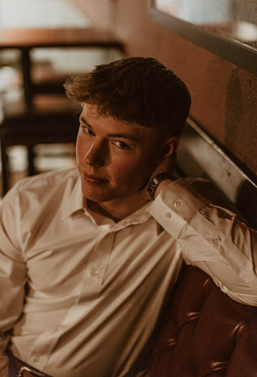 highschool male senior poses in front of bar 