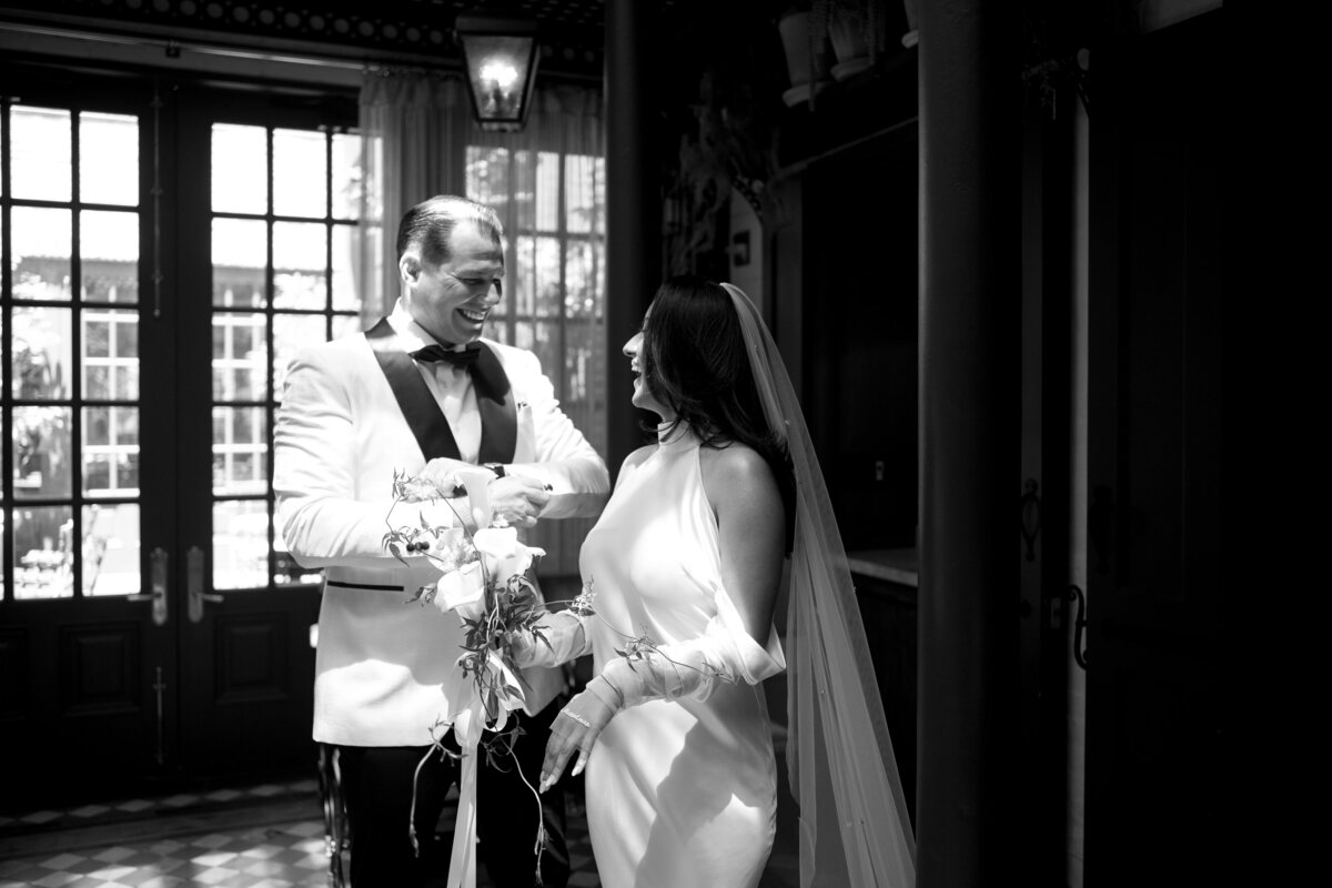 Black and white photo of bride and groom smiling together during their elopement at Hotel Chelsea in New York City, captured by NYC wedding photographer Perry Hancock.