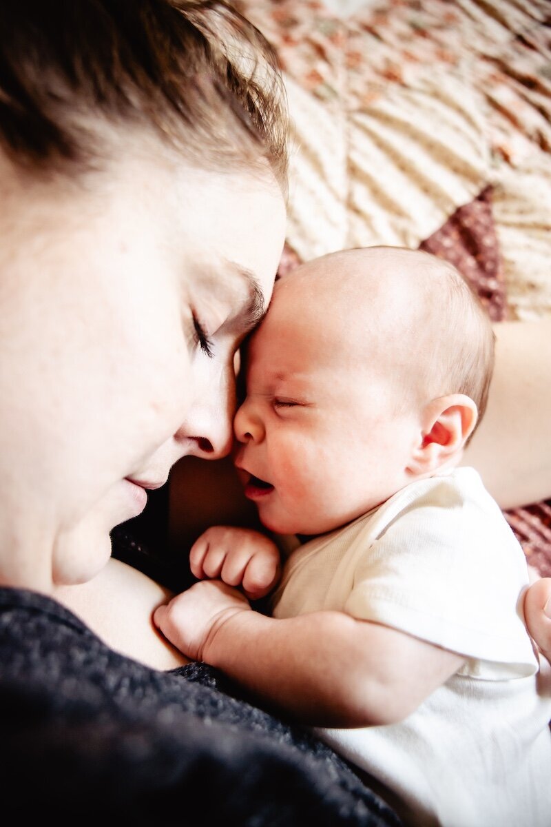 a baby girl fast asleep next to her mom