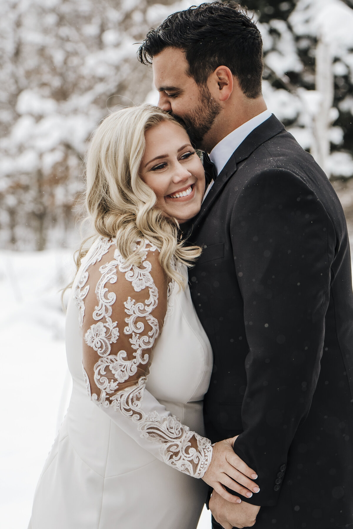 A couple sharing a tender moment in a winter wonderland, with gentle snowflakes adding a touch of magic to their embrace. Taken by jen Jarmuzek photography a Minneapolis wedding photographer